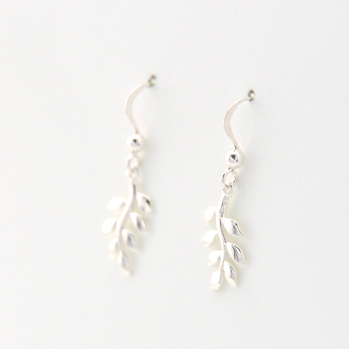 Silver leaf-shaped earrings on a white background