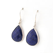 Teardrop-shaped blue lapis earrings with silver hooks on a white background
