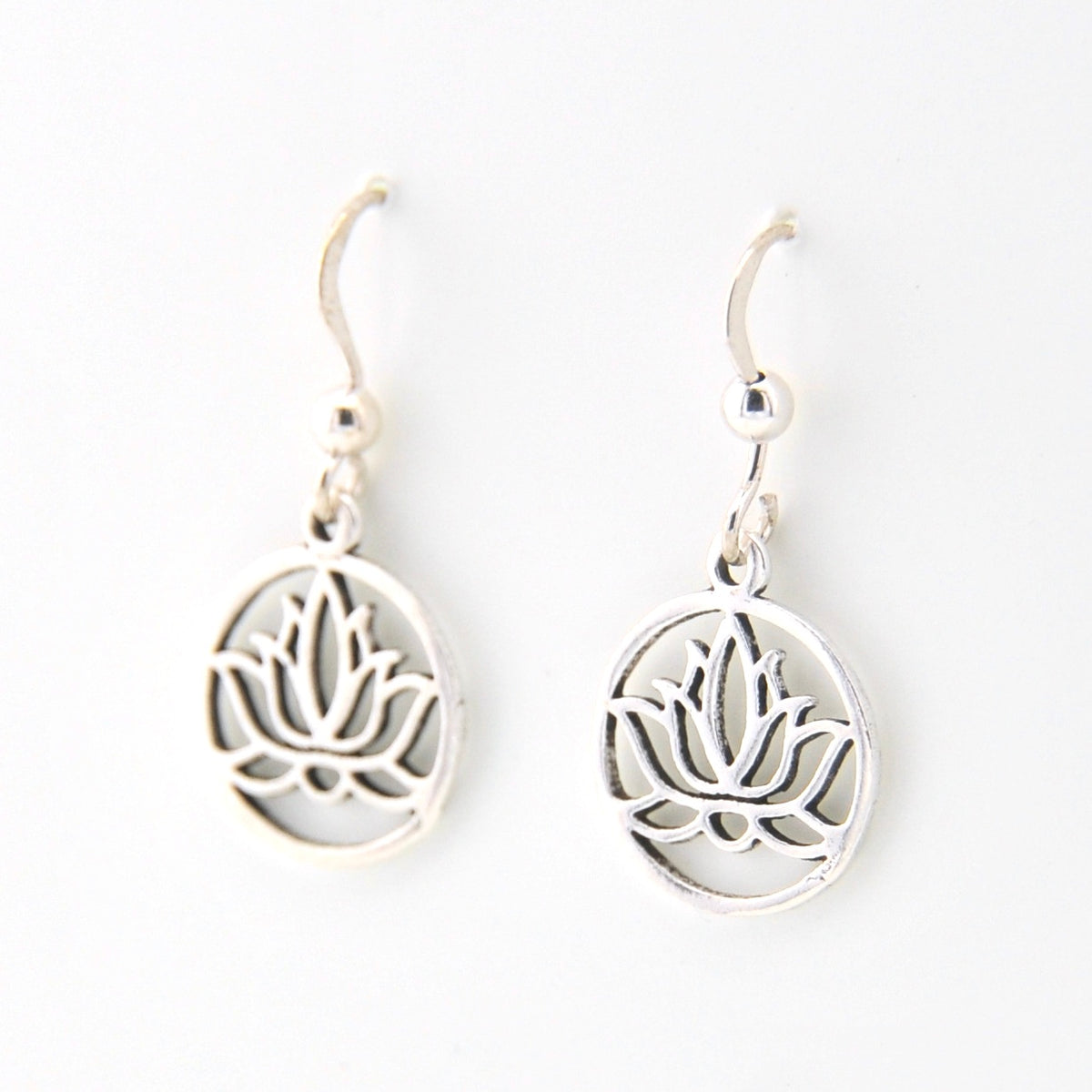Silver lotus flower earrings on a white background