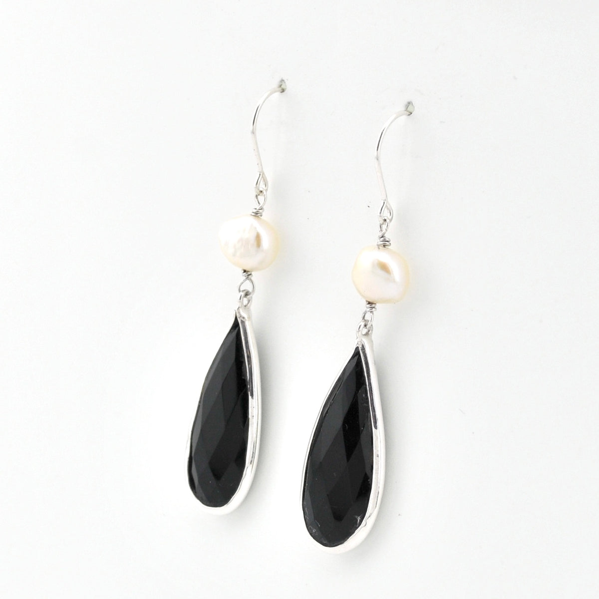 Black teardrop earrings with white stones on a white background