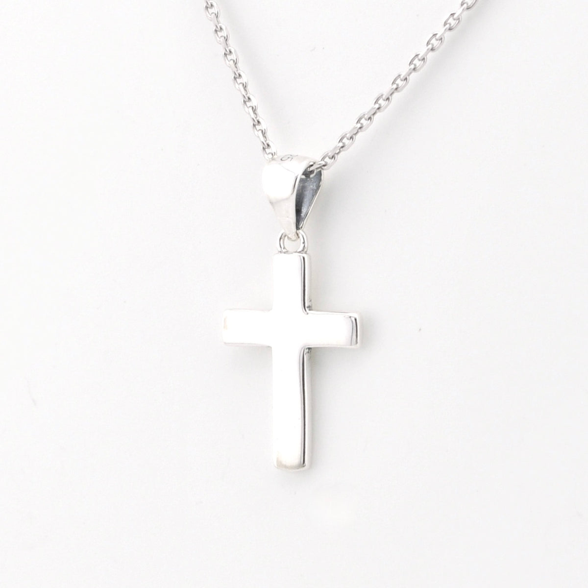 Silver cross necklace on a white background
