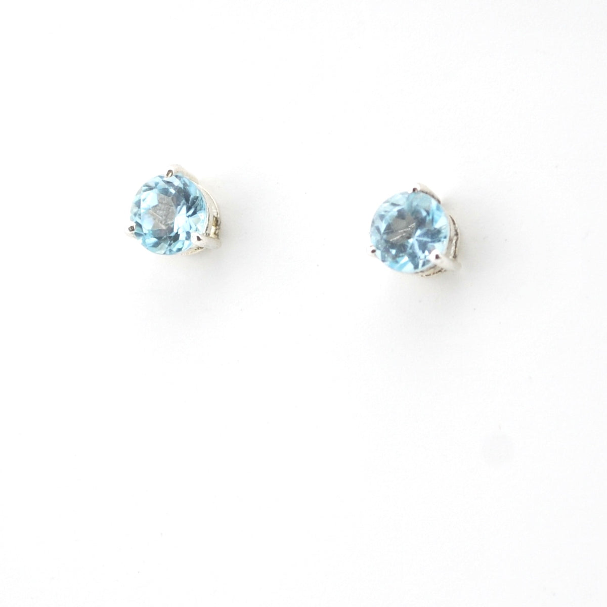 Pair of round blue gemstone stud earrings on a white background