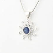 Silver sun-shaped pendant with a blue stone on a white background