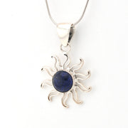 Silver sun-shaped pendant with a blue stone on a white background