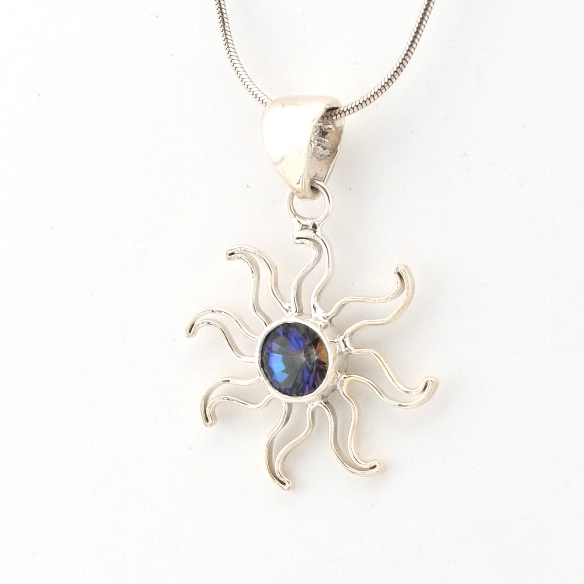 Silver sun-shaped pendant with a blue gemstone on a white background