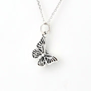 Silver butterfly charm on a gray background