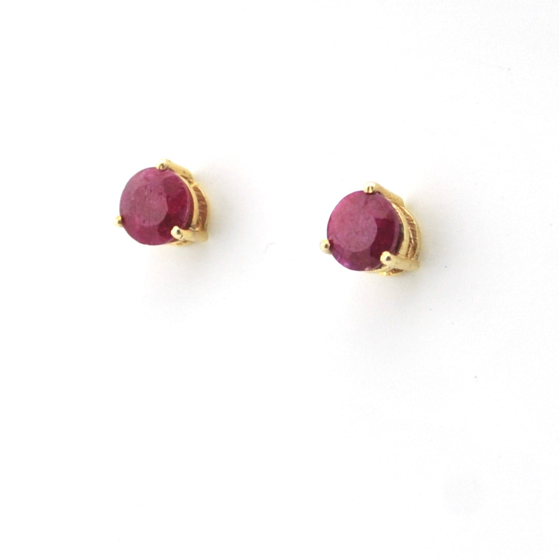 Pair of gold earrings with red gemstones on a white background