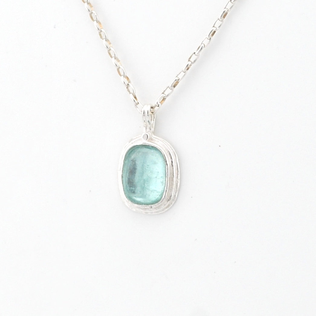 Necklace with a pendant featuring a aqua Roman glass on a white background