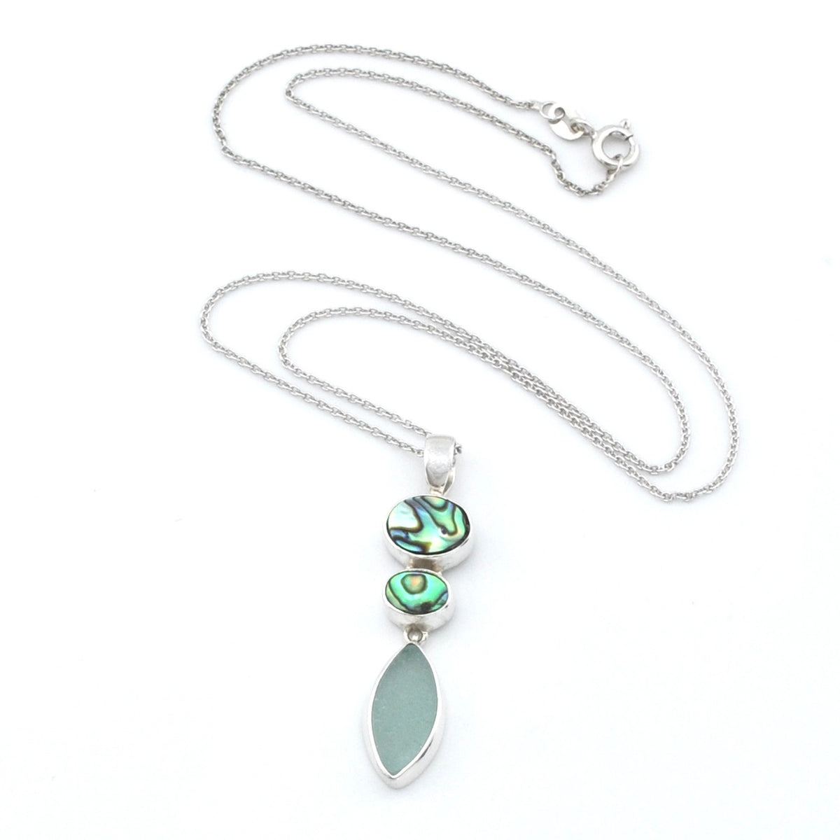 A silver necklace featuring a vertical pendant with two iridescent abalone stones and a large, smooth, light green teardrop-shaped sea glass, displayed on a white background.