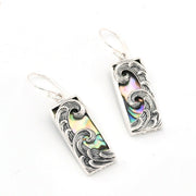 Silver earrings with abalone shell inlay on a white background