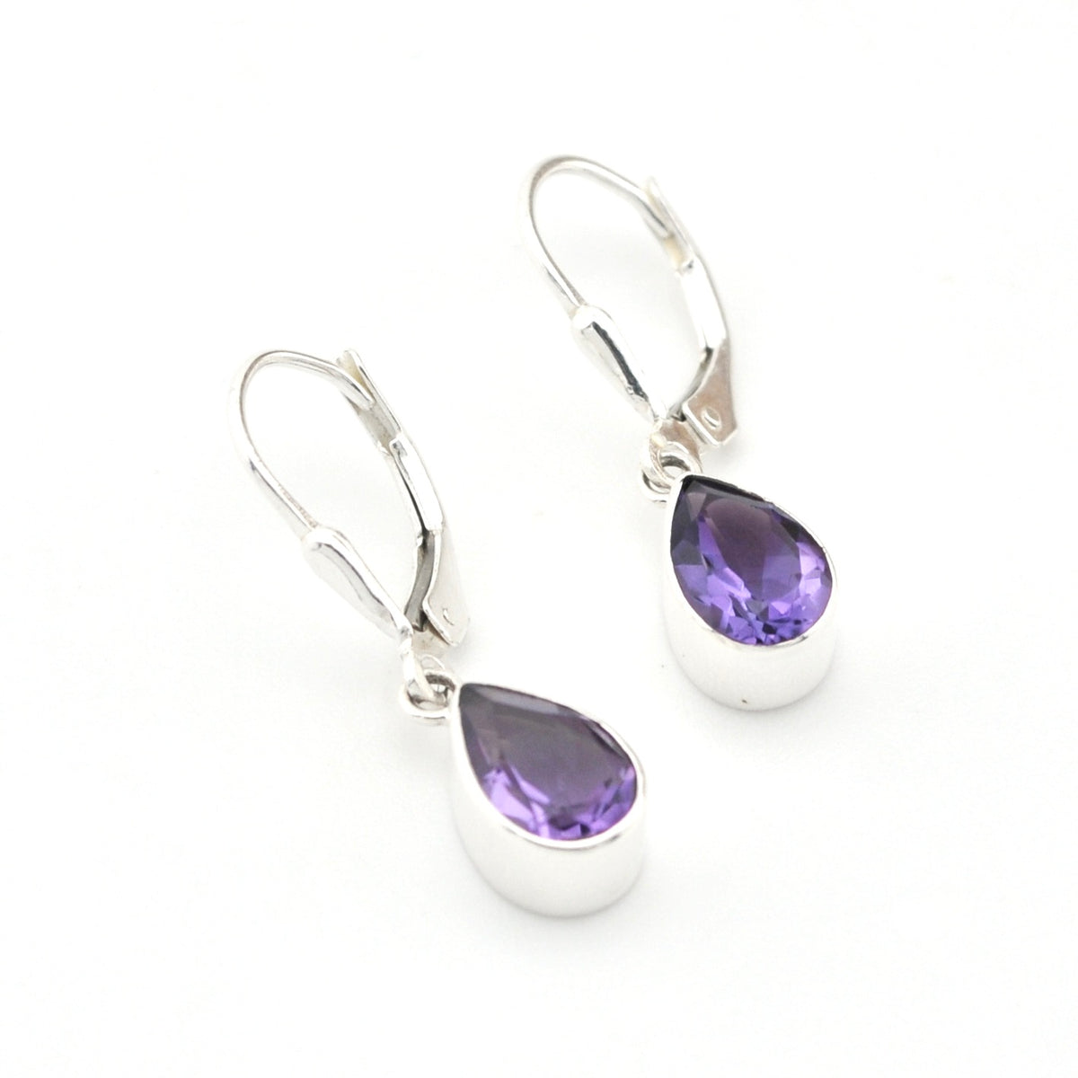 Silver earrings with purple teardrop-shaped gemstones on a white background