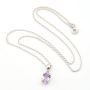 Silver necklace with a purple pendant on a white background