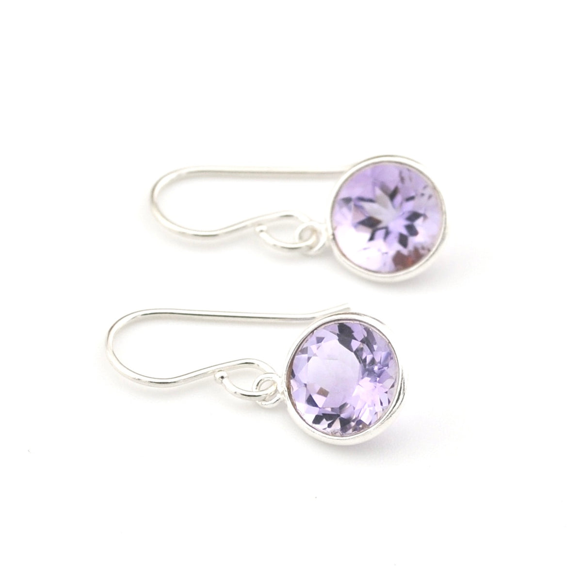 Silver earrings with purple gemstones on a white background