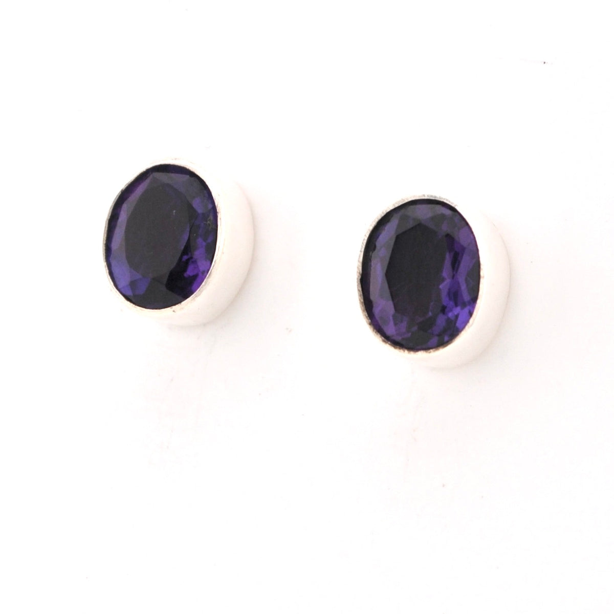 Pair of purple gemstone earrings on a white background