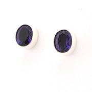 Pair of purple gemstone earrings on a white background