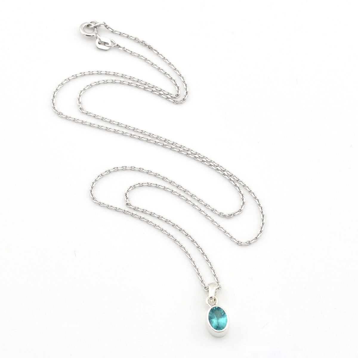 Silver necklace with a blue pendant on a white background