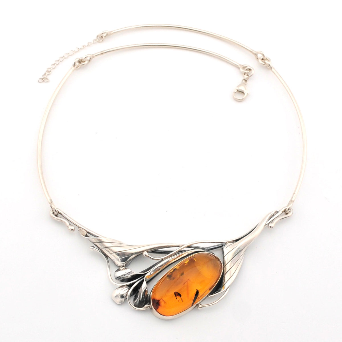 Silver necklace with an amber pendant on a white background