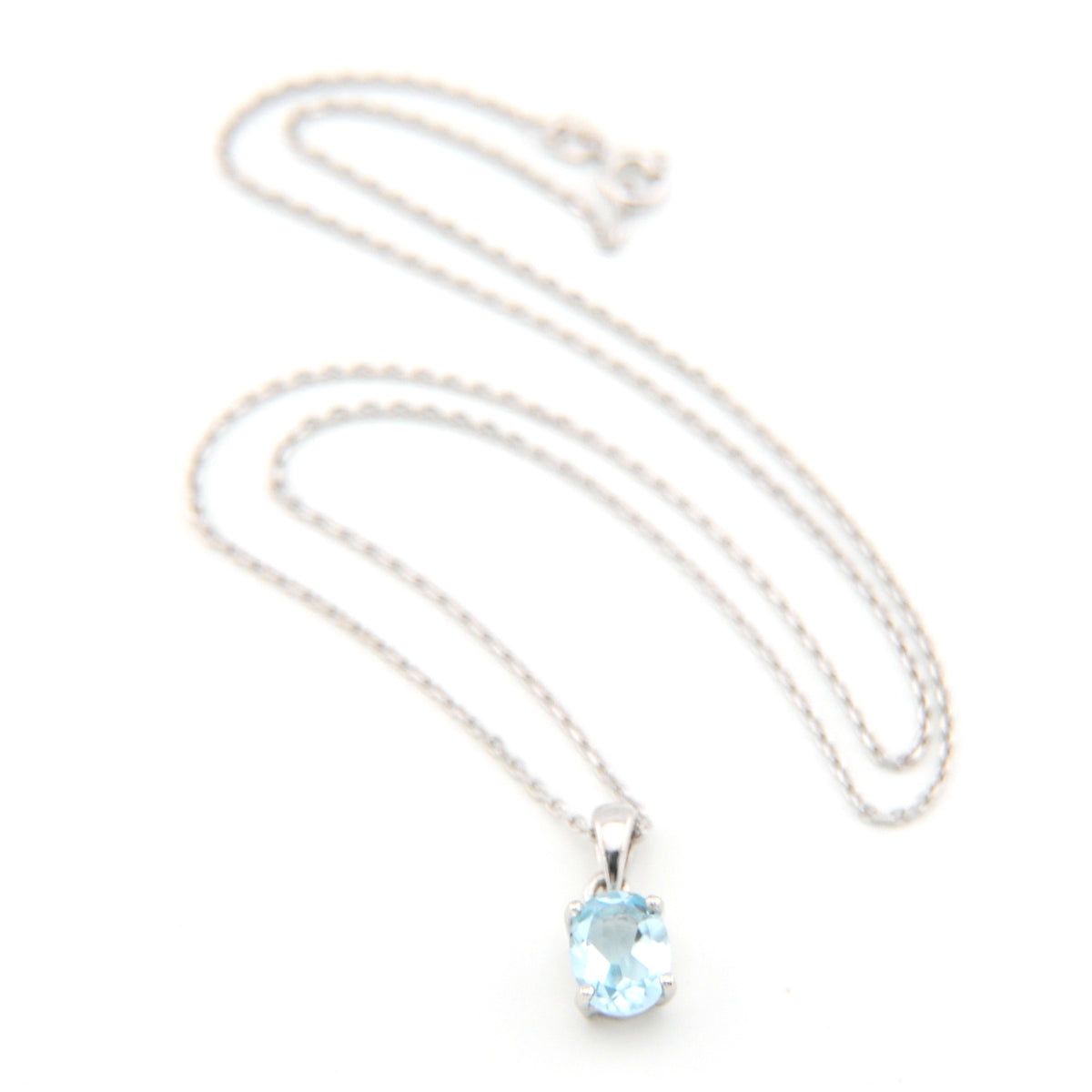 Silver necklace with a blue gemstone pendant on a white background