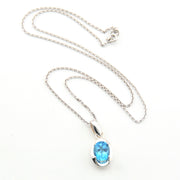 Silver necklace with a blue gemstone pendant on a white background