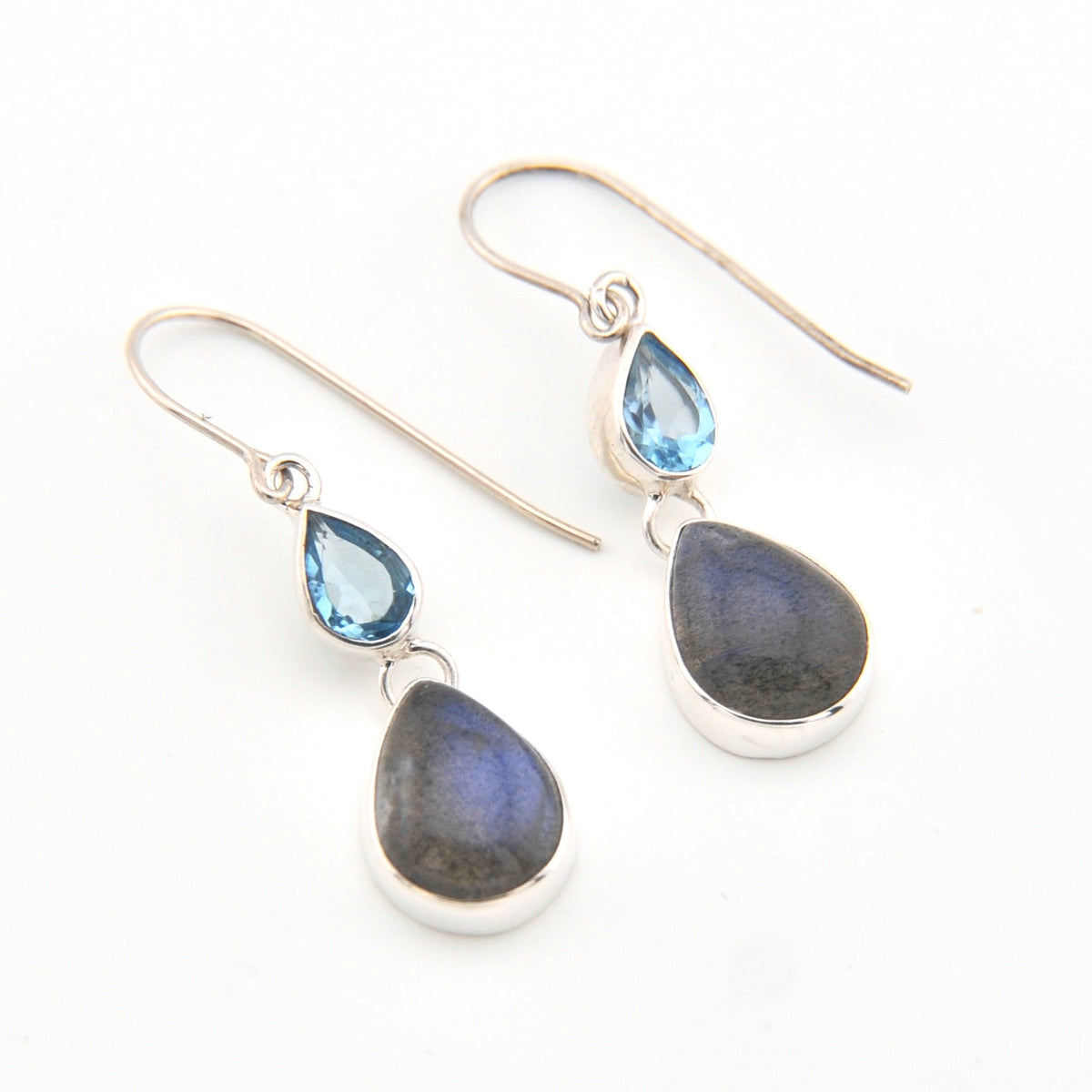 Pair of silver earrings with teardrop-shaped gemstones on a white background