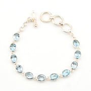 Silver bracelet with blue gemstones on a white background