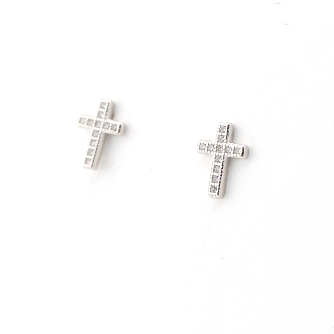 Pair of silver cross earrings on a white background