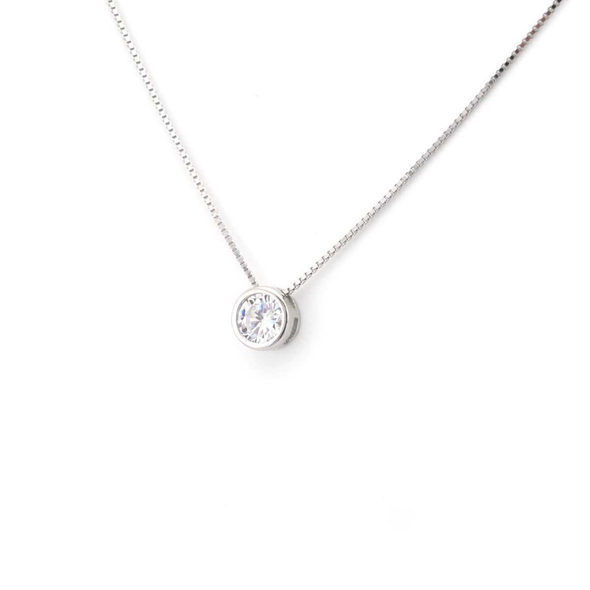 Silver necklace with a round pendant on a white background