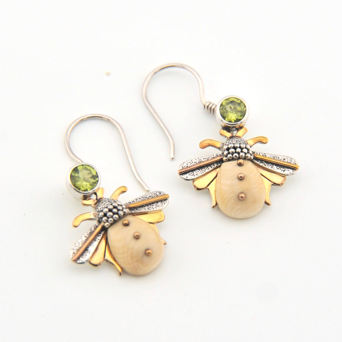 Bee-shaped earrings with gold and silver details on a white background