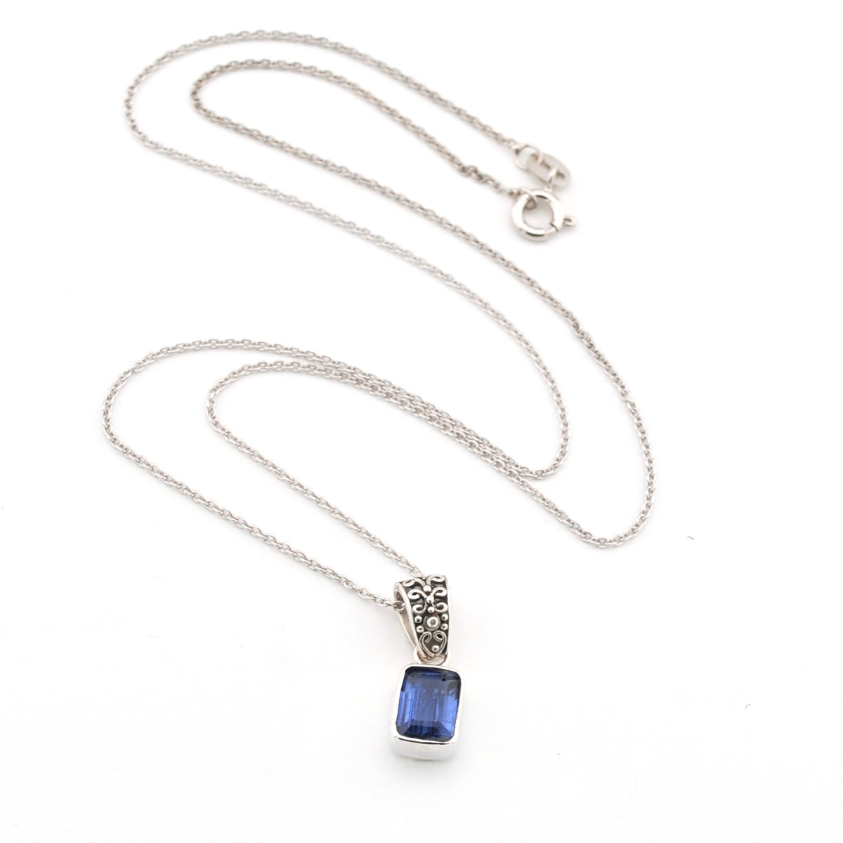 Silver necklace with a blue kyanite pendant on a white background