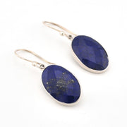 Pair of lapis stone earrings with silver hooks on a white background