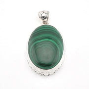 Green stone pendant with silver setting on a white background