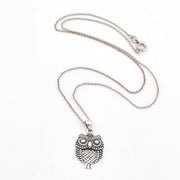 Silver owl pendant necklace on a white background