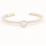 Silver bracelet with a pearl on a white background