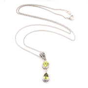 Silver necklace with two green peridot gemstones on a white background