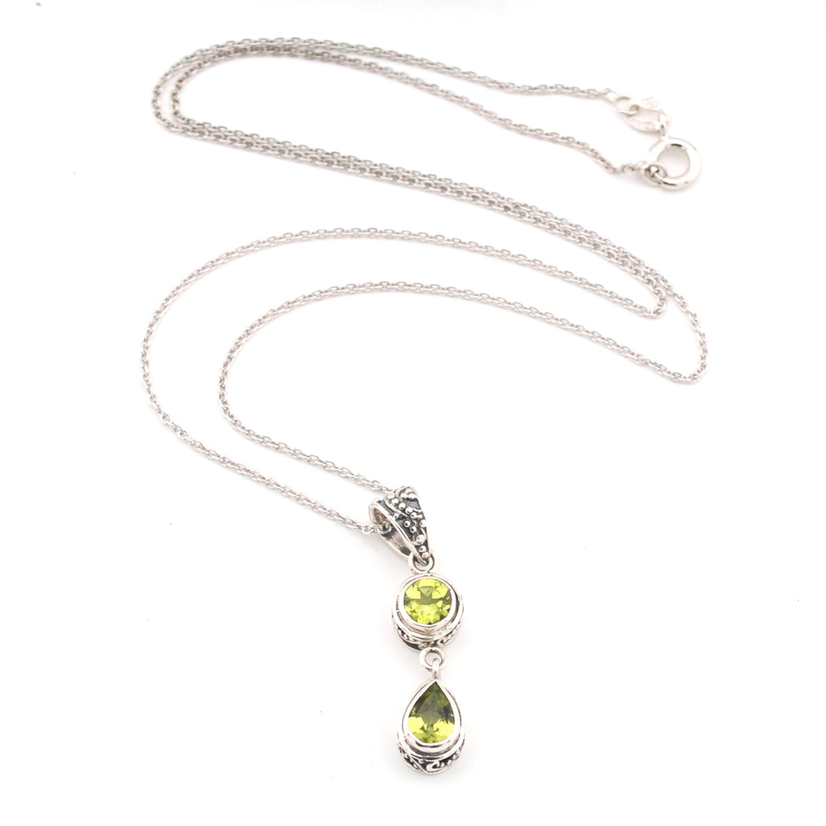 Silver necklace with two green peridot gemstones on a white background