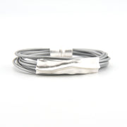 Silver bracelet with a textured clasp on a white background