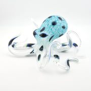 Glass octopus figurine with blue and black pattern on a white background