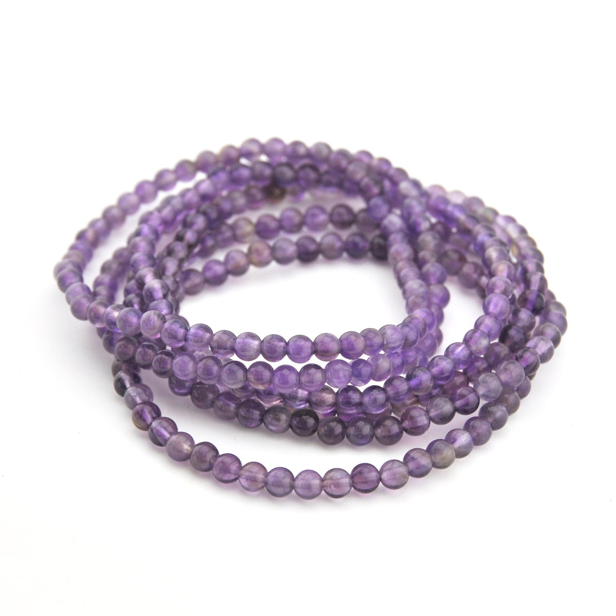 Stack of purple beaded bracelets on a white background