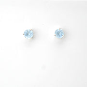 Pair of round light blue gemstone stud earrings on a white background