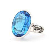 Silver ring with a blue gemstone on a white background