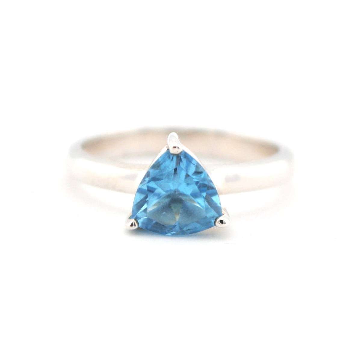 Silver ring with a trapezoid-shaped blue gemstone on a white background