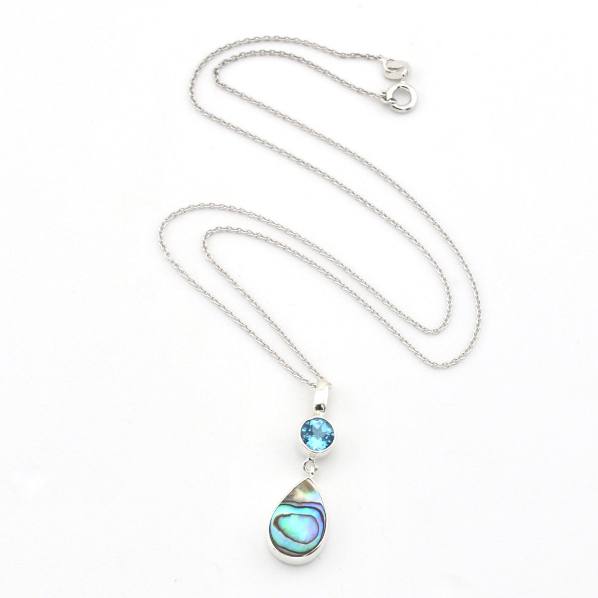 A silver necklace featuring a teardrop-shaped abalone shell pendant and a small round blue gemstone, displayed on a clean white background.