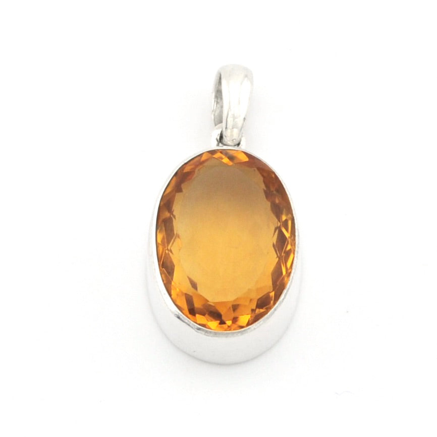 An oval faceted amber-orange gemstone pendant set in a polished silver bezel with a silver bail, shown on a plain white background.