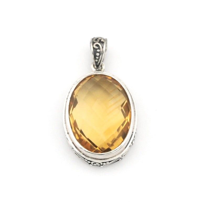 An oval-cut yellow citrine gemstone pendant set in a silver-toned metal bezel with an ornate bail, shown on a plain white background.