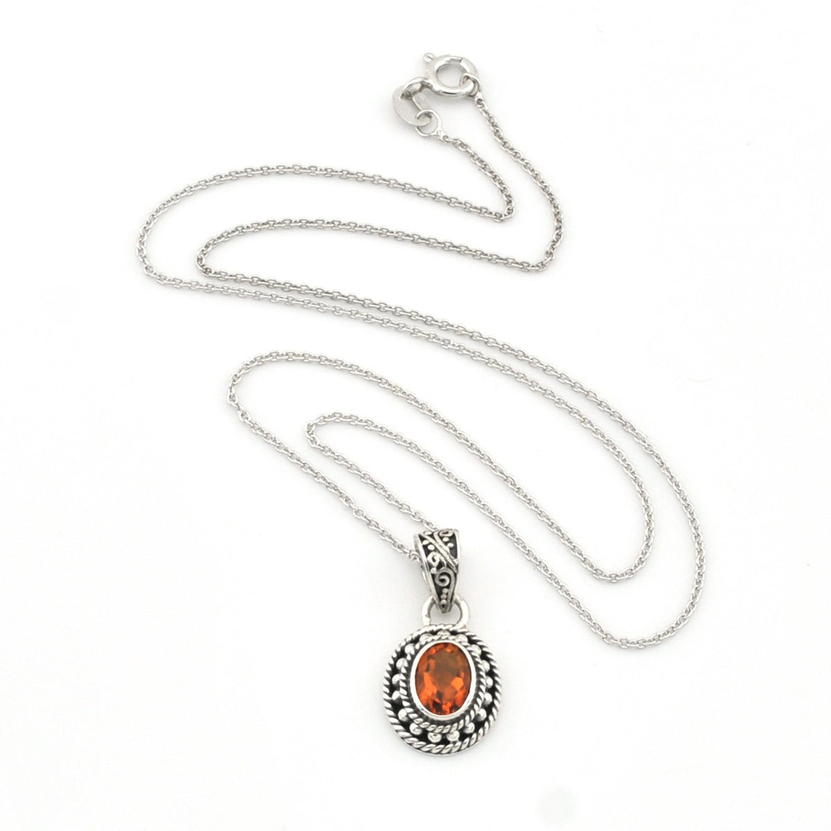 A silver chain necklace with an oval pendant featuring a vibrant orange gemstone surrounded by a textured silver border, displayed on a clean white background.