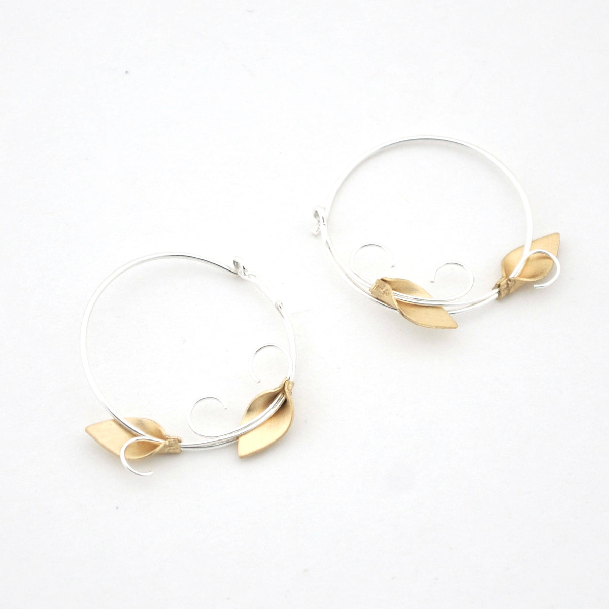 Hoop earrings with gold leaf accents on a white background