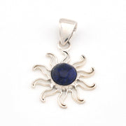 Silver sun-shaped pendant with a blue gemstone on a white background