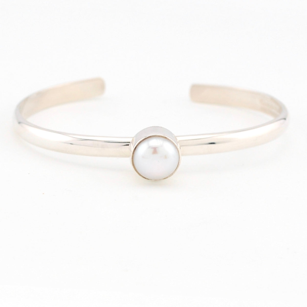 Silver bracelet with a single pearl on a white background
