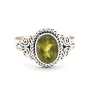 Silver ring with a green gemstone on a white background