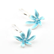 Pair of light blue flower-shaped earrings on a white background